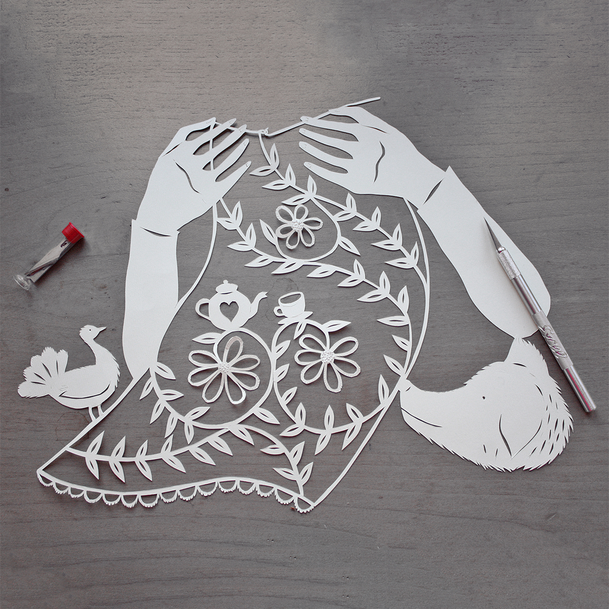 Ilustração em papercut de mãos a fazer crochet com pomba e cão