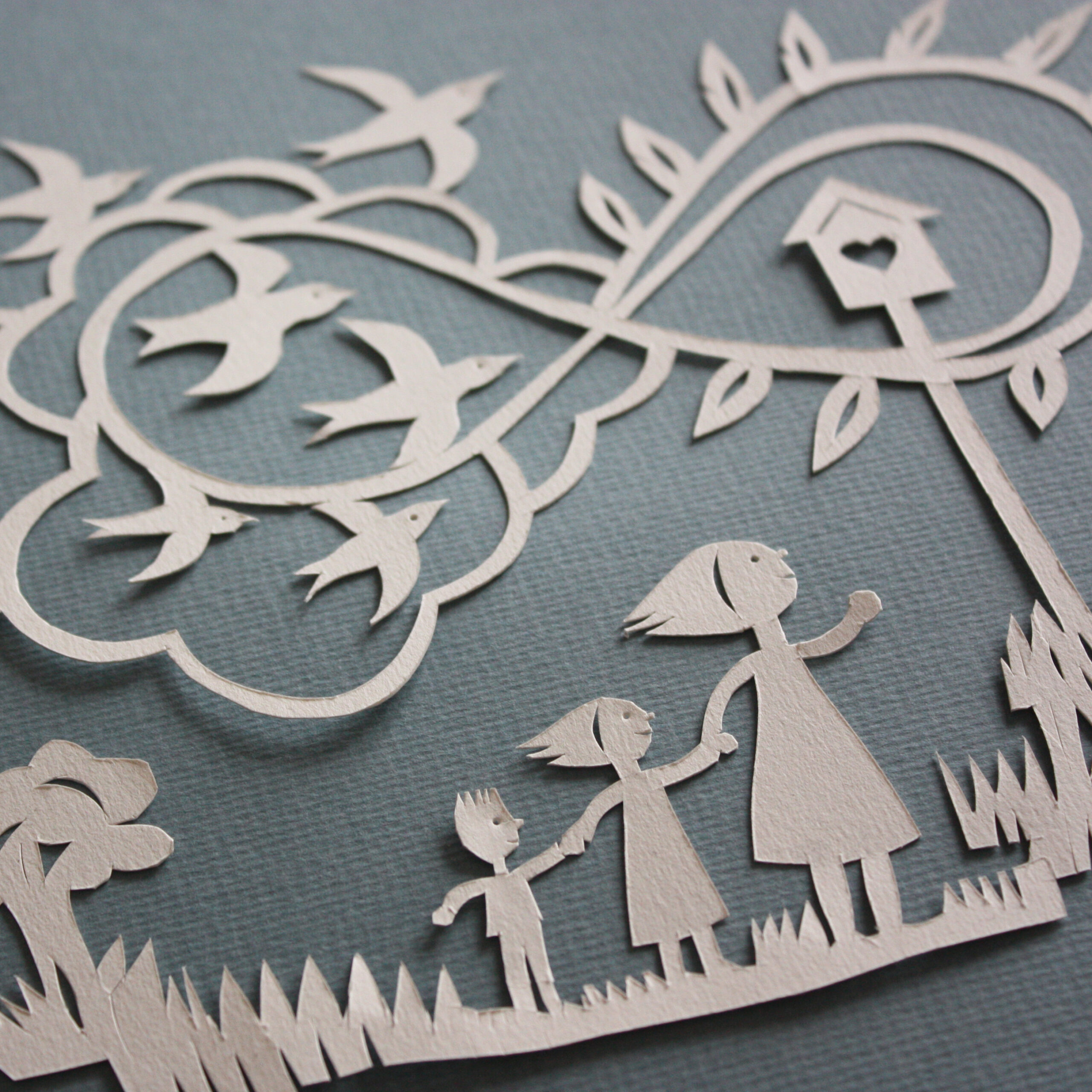 Pormenor de quadro com Ilustração em papercut de mãe e crianças a olhar para andorinhas no infinito.